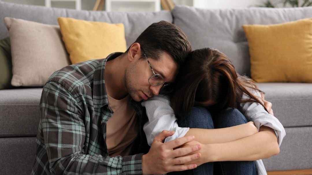 man and woman embracing in sadness